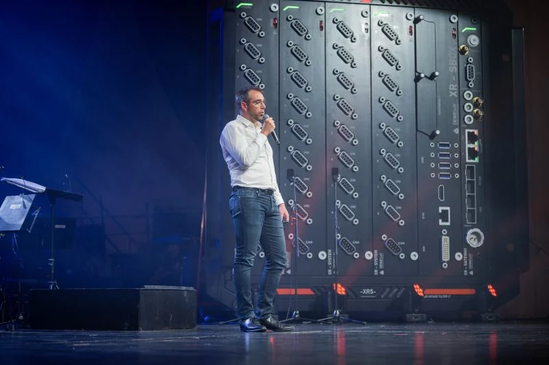 The keynote on stage, in front of a data acquisition rack