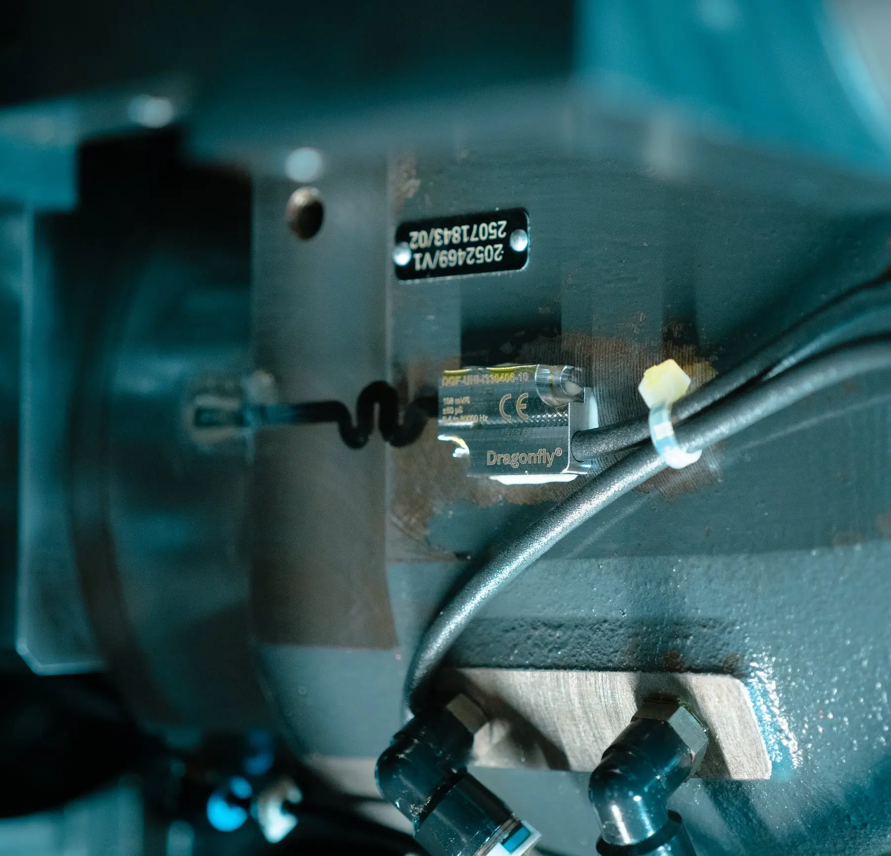 A Dragonfly® sensor bonded on an industrial gearbox, its cable tied along the housing.